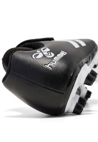 Botte de football synthétique noire avec marquage blanc, bout arrondi, tige texturée et semelle à pointes pour l'adhérence. Présente un design épuré.