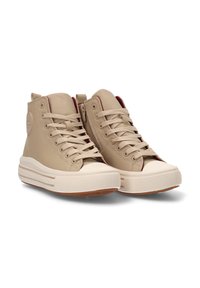 Zapatillas altas beige con parte superior de cuero suave, puntera de goma crema y suela de goma texturizada; cuenta con cordones y un parche con logo.