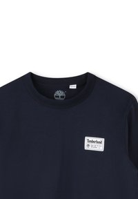 Navyblauwe T-shirt van katoen, met een ronde hals, korte mouwen en een wit Timberland logo op de linkerborst.