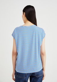 T-shirt rayé en coton bleu clair et blanc, avec des manches courtes et un col rond. La vue de dos montre une coupe décontractée et une texture douce.