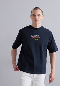 Must musta T-särk lühikeste varrukatega, millel rindkere peal on mitmevärviline tikandiga tekst "DSQUARED2 SUVE ARMUJAD XOXO".