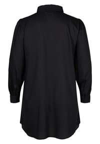 Longue blouse noire avec manches longues bouffantes, poignets boutonnés et un ourlet droit vue de dos sur fond blanc.