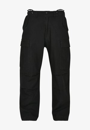 Mustard värvi tunkepüksid, mis on valmistatud vastupidavast kangast. Omab mitmeid taskuid, lõdva istuvuse ja lukuga fly, millel on nööbiga kinnitamine. tugevdusõmblused õmblustes.