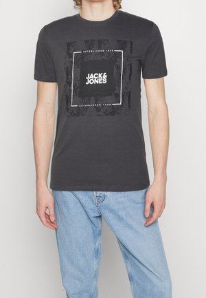Dark gray cotton t-shirt with a square graphic featuring "JACK & JONES" in white. Classic crew neck, short sleeves, relaxed fit.