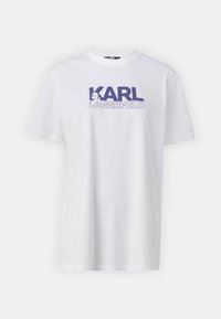 Weißes Baumwoll-T-Shirt mit einem großen lila Grafik und dem Text "KARL LAGERFELD" in fetter Schrift. Klassischer Rundhalsausschnitt und kurze Ärmel.