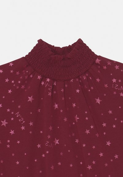 Top de tecido bordô com decote franzido, apresentando estrelas brilhantes rosas espalhadas e acentos de texto em um design divertido.