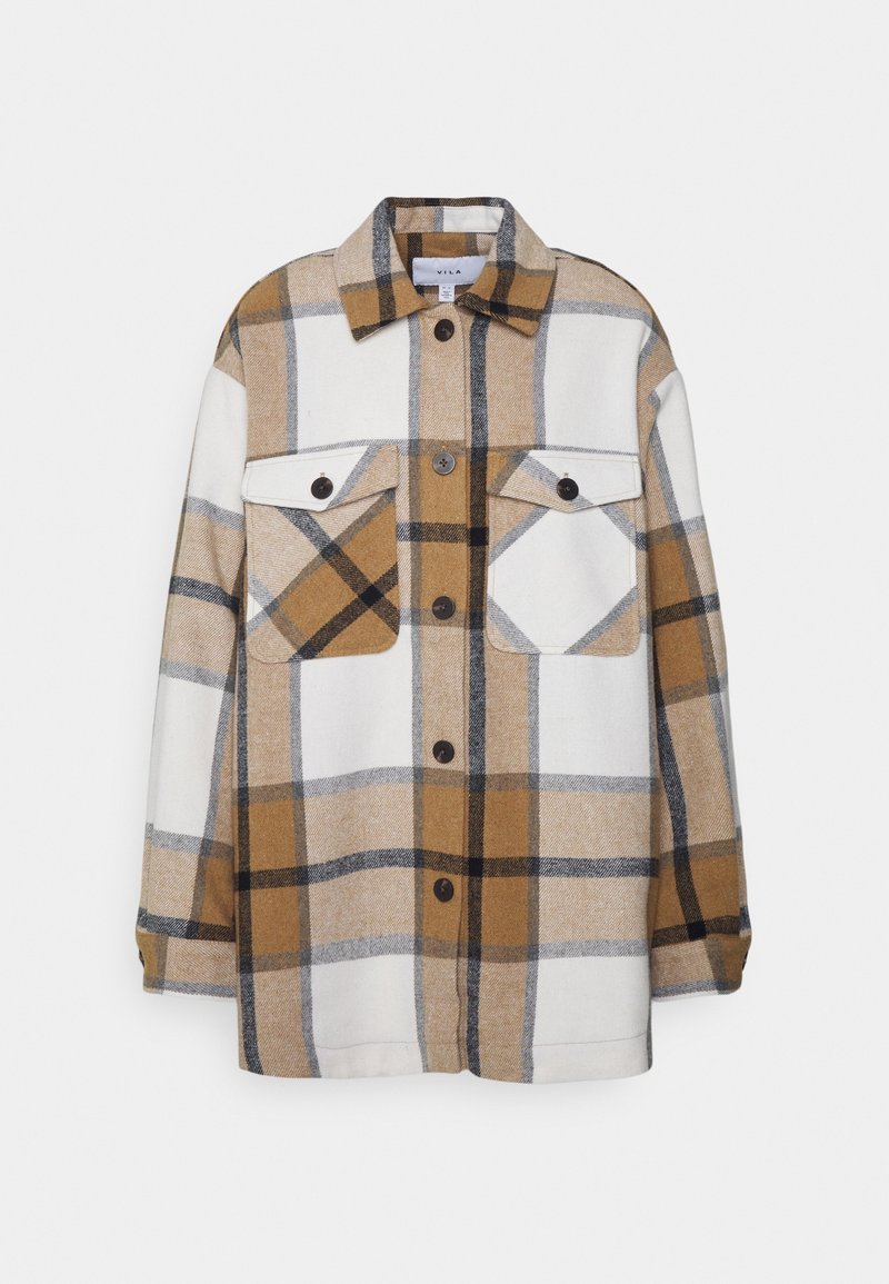Chemise-veste à manches longues à boutons avec un grand motif à carreaux beige, marron, noir et blanc et deux poches avant à rabat boutonné.