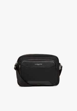 Borsa a tracolla nera realizzata in materiali lisci e testurizzati, con una tasca frontale, tracolla regolabile e dettaglio del logo in tonalità argentata.