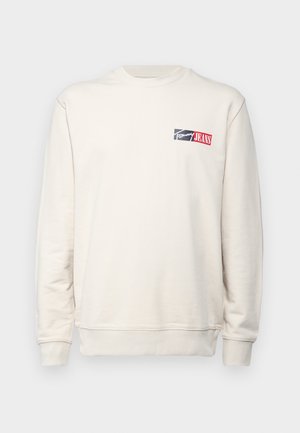 Lichtbeige sweatshirt met lange mouwen, geribbelde ronde hals en een klein logo in marineblauw en rood op de linkerborst. Zachte stoftextuur.