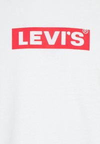 Weißes Baumwoll-T-Shirt mit einem auffälligen roten Rechteck und dem Schriftzug "LEVI'S" in weißer, fetter Schrift, mittig auf der Brust platziert.