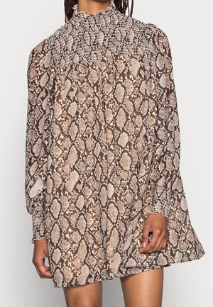 Ruskea käärmekuosisekuvioinen mekko, jossa korkea röyhelökaulus, pitkät hihat ja olkapäillä sekä hihoissa smokkaukset. Kevyt ja laskeutuva kangas.