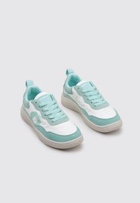 Baskets bleu clair et blanches avec un upper en cuir lisse, des semelles en caoutchouc texturé et des lacets assortis. Présentant un accent logo sur le côté.