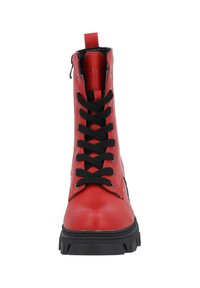 Botín de cuero rojo hasta el tobillo con cordones negros, una cremallera en el lateral y una suela negra robusta. Cuenta con un tirador en la parte posterior para facilitar el uso.