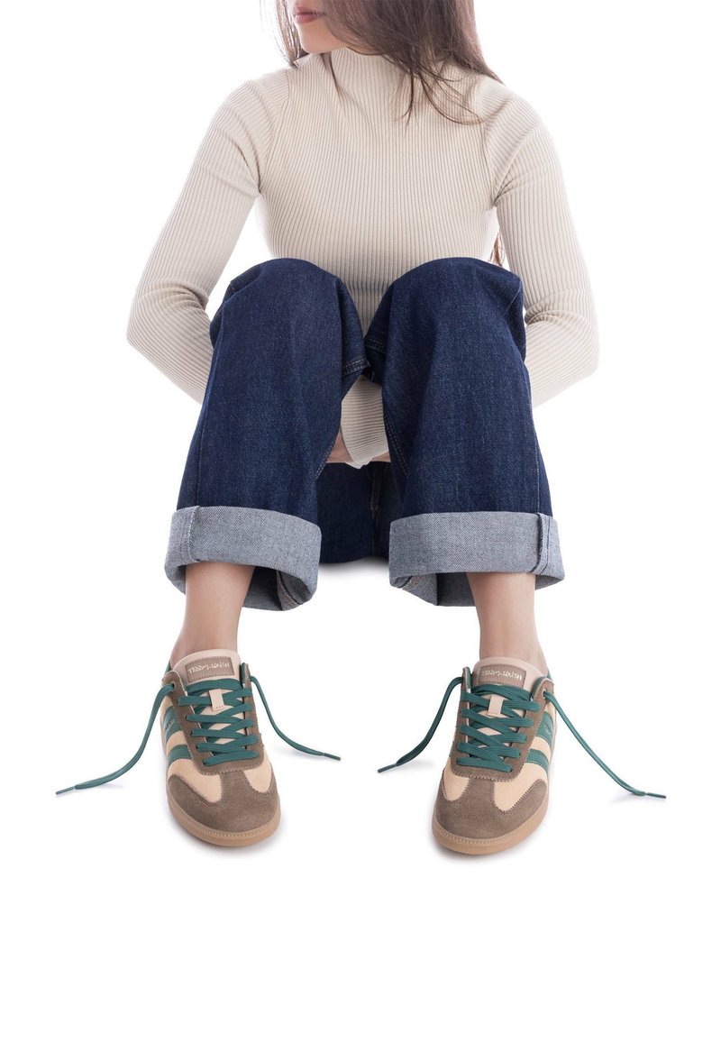 Zapatillas marrones y beige con cordones en color teal, con una parte superior de ante y tejido. El diseño destacado incluye rayas en contraste y una puntera redondeada.