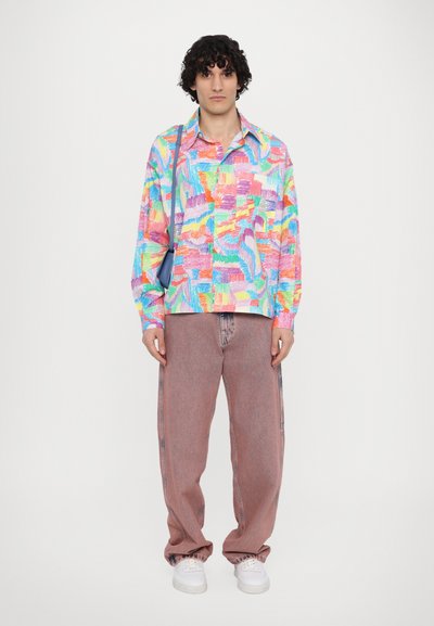 Multikleurige langarmshirt met abstracte patronen, gecombineerd met losse roze spijkerbroek en witte sneakers. Opvallende kenmerken zijn de gladde textuur.