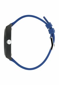 Montre analogique avec un boîtier rectangulaire noir, un bracelet en silicone bleu, un détail logo argenté et un design minimaliste aux surfaces lisses.