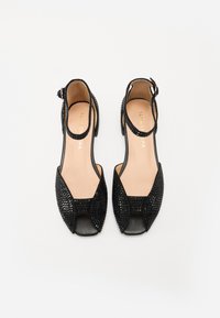 Mustad avatud varbaga slingback-kingsad, millel on tekstuurse võrkmaterjaliga pealis, sile nahksisustus ja väike konts. Reguleeritav pahkluu rihm.
