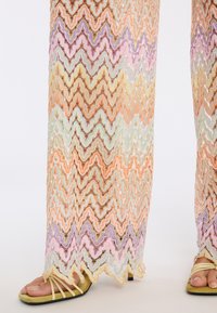 Spitzenhosen mit einem Zickzackmuster in Pastellfarben wie Pfirsich, Lavendel und Minzgrün; versehen mit einer gewellten Kante und einer durchbrochenen Textur.