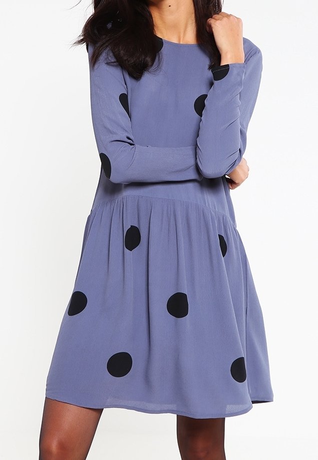 Pitkähihaista, polvenpituista hametta vaaleanliilasta kankaasta, jossa on mustia pilkkuja. Mekossa on istuva yläosa ja liehuvahelma.