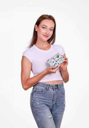 Peněženka s květinovým vzorem v mintově zelené barvě s hladkým povrchem, držena osobou v bílém crop topu a modrých džínech.
