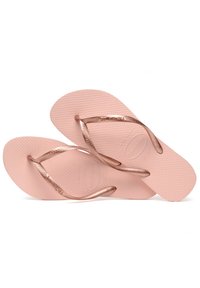 Rosa gummisandaler med en teksturert såle og metalliske roségull stropper. Har et merket logo på sålen. Lettvekts og fleksibel design.