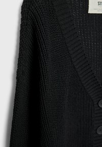 Czarny dziergany kardigan z prążkowanym kołnierzem w kształcie litery V i zapięciem na guziki, pokazujący szczegółową teksturę grubego dzianego materiału.