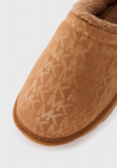 Brun toffel med en mjuk, texturerad utsida som har ett guldstjärnmönster. Inuti är den klädd med ett plyschmaterial för komfort. Rundad tådesign.