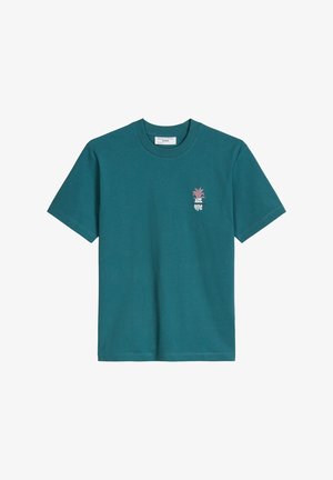 Morska zieleń krótkiego rękawa koszulka z dekoltem crewneck, z małą różową grafiką ananasa i białym stylizowanym tekstem na lewej piersi.