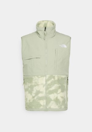 Veste sans manches vert clair avec col montant, fermeture éclair à l'avant, poches poitrine et latérales, partie supérieure en tissu lisse et partie inférieure en texture duveteuse.
