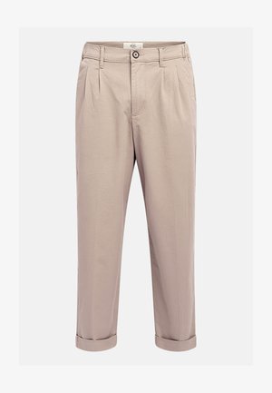 Beige plisserade byxor gjorda av en bomullsblandning. Manschetter i nederkant och en knappstängning i midjan. Har sidofickor och en slät yta.