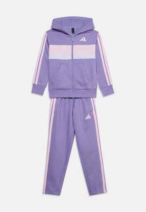 Chándal infantil en lila y rosa claro con chaqueta con capucha y cremallera y pantalones a juego, con rayas y pequeño logo en el pecho y el muslo.