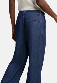 Mørkeblå denimbukser med en avslappet passform, som har middels høyde i livet, baklommer og subtile sømdetaljer.
