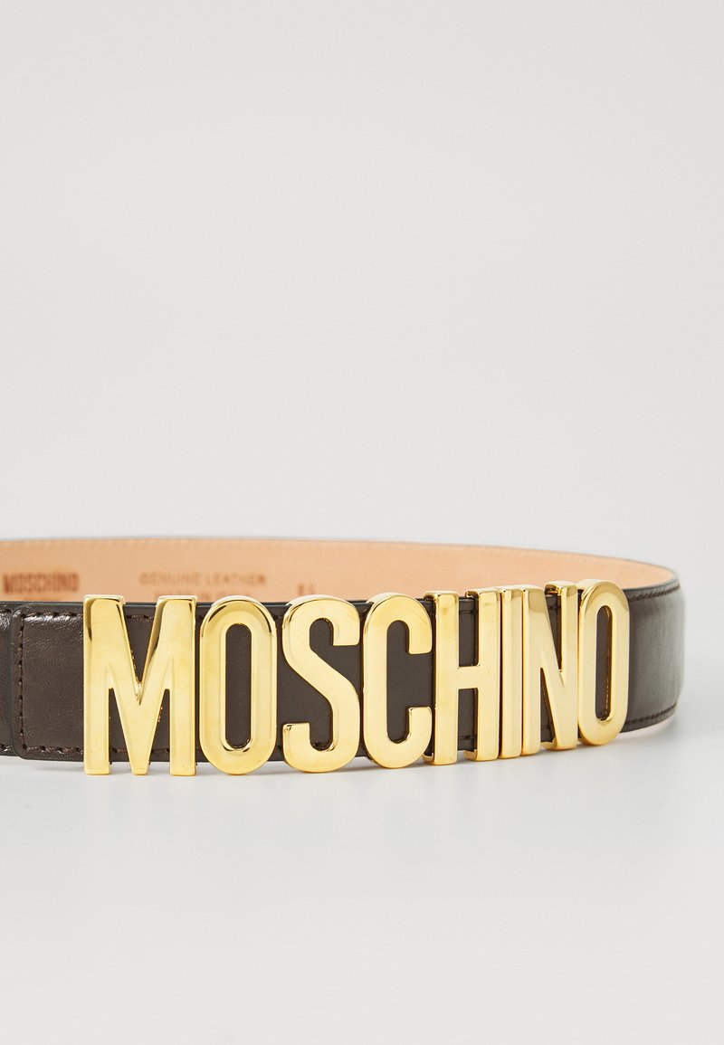 Brown leather belt featuring a prominent gold-tone "MOSCHINO" logo at the front. Smooth texture with a classic design.