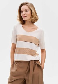 V-hals trui in lichtbeige met horizontale strepen in tan en bruin. Zacht gebreid materiaal met textuurdetail aan de onderkant.