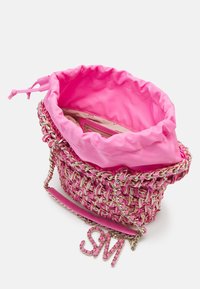 Petit sac à main tissé rose avec bandoulière chaîne dorée et doublure en tissu rose avec cordon, affiché ouvert avec une poche intérieure zippée visible.