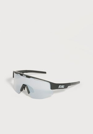 Lunettes de sport Bliz à monture noire avec une lentille grise réfléchissante unique et un coussinet nasal doux sur fond blanc.