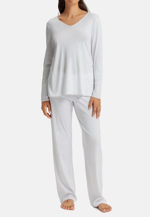 Top bianco a maniche lunghe con scollatura a V, abbinato a pantaloni da pigiama larghi dello stesso colore. Tessuto morbido e liscio con un design minimalista.