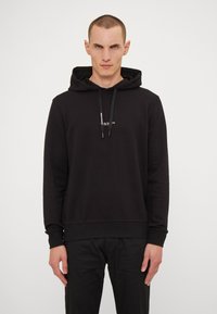 Black hoodie made of soft fabric, featuring a front kangaroo pocket, drawstring hood, and a small white logo on the chest.