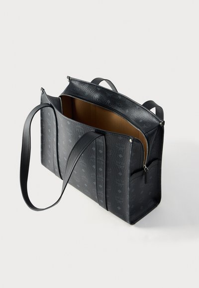 Μαύρη δερμάτινη τσάντα με υφή, διπλές χειρολαβές, κλείσιμο με φερμουάρ, κύριο εσωτερικό διαμέρισμα και διακριτικές λεπτομέρειες με μοτίβο.