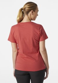 Camiseta de manga corta en algodón coral, con un cuello redondo y un diseño simple, sin adornos. Textura suave, ajuste casual.