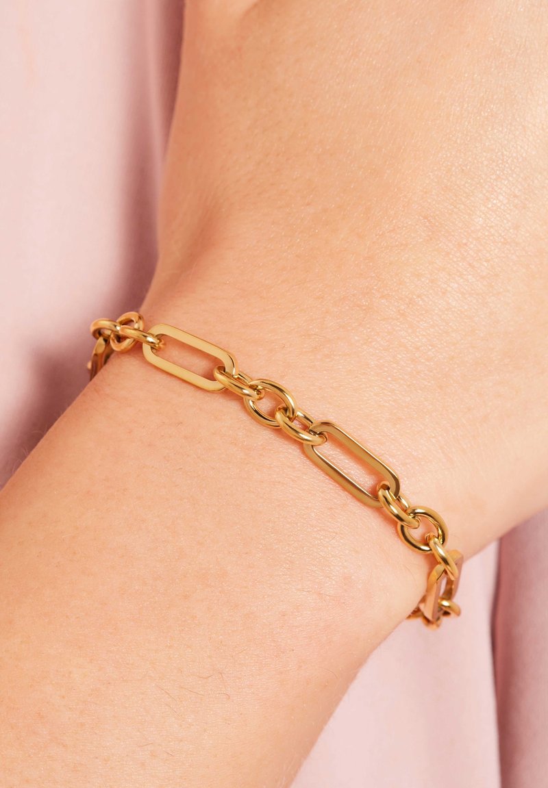 Gouden kettingarmband met langwerpige rechthoekige schakels en ronde accenten, waarbij een gepolijste metalen afwerking wordt getoond.