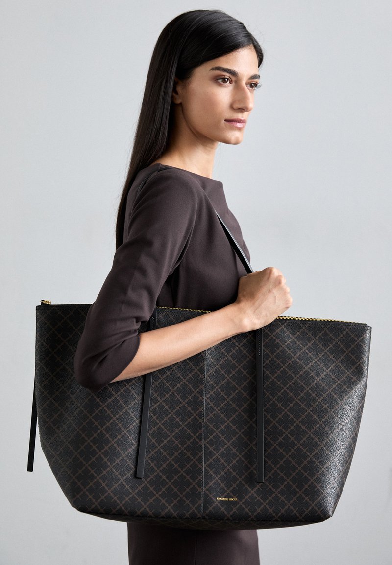 Grande borsa tote rettangolare in pelle sintetica marrone scuro con un motivo geometrico, dotata di due lunghe cinghie nere e una cerniera dorata.