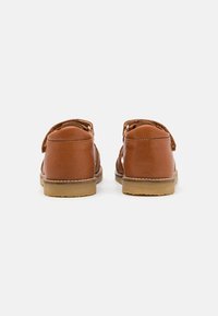 Brune lærstøvler med en glat finish, rund hæl og Velcro-lukning. Gummi sål med et minimalt mønster, designet til komfort og lethed.