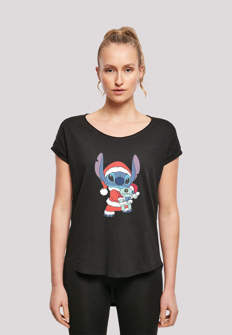 Black short-sleeve t-shirt made of soft fabric featuring a colorful graphic of Stitch in a Santa outfit holding a toy. Relaxed fit.