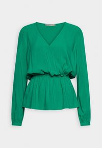 Top peplum verde con maniche lunghe, scollatura a V e vita arricciata. Realizzato in tessuto morbido con una texture fluida e dettagli di design minimi.