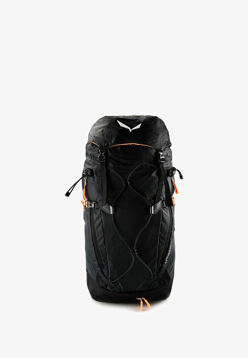 Mochila de senderismo negra con múltiples correas, hebillas, bolsillos laterales y tiradores de cremallera naranjas, diseñada para actividades al aire libre y alpinas.