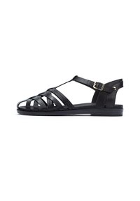 Sandalias de cuero negro con diseño de tiras trenzadas, correa ajustable en el tobillo con hebilla, suela plana y estilo minimalista.