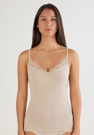 Camiseta de tirantes color beige con delicado encaje en el escote, tirantes finos y un diseño ajustado, hecha de una tela suave y lisa.