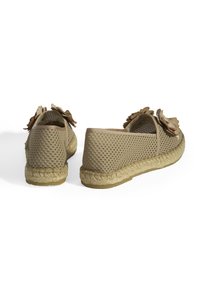 Beige mesh espadrilles met bloemaccenten, textuur aan de zijkanten en jute-achtige zolen. Open ontwerp en ronde vorm, geschikt voor warm weer.