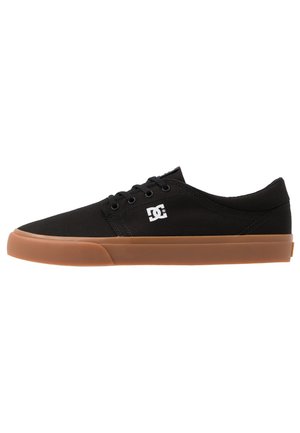 Black canvas sneakers with a rounded toe, rubber gum sole, and DC logo on the side. Features six eyelets with black laces.